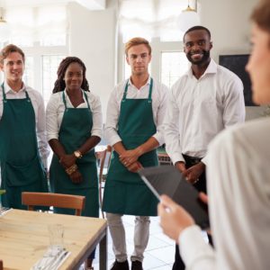 Staff Attending Team Meeting In Empty Dining Room