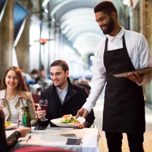 Waiter serving restaurant guests at a table